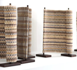 Evolution II, 2020, Cotton, rusted steel three scroll like sculptures with handwoven fabric and rusted steel. Neutral color palette.